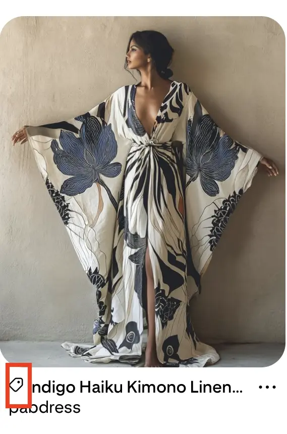 Example of product rich Pin with the image of a woman posing elegantly against a wall in a floral kimono-style dress with flowing sleeves and a plunging neckline. The fabric features large indigo flowers. A red box highlights a price tag icon below the image.